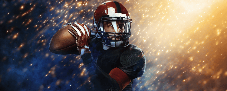 A football player poses while holding the ball